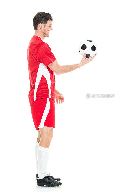全身/一人/一人/侧视图/ 30-39岁英俊的人白人男性/中年成年男子/中年成人足球运动员杂耍/穿着足球制服站在白色背景前/运动/膝盖